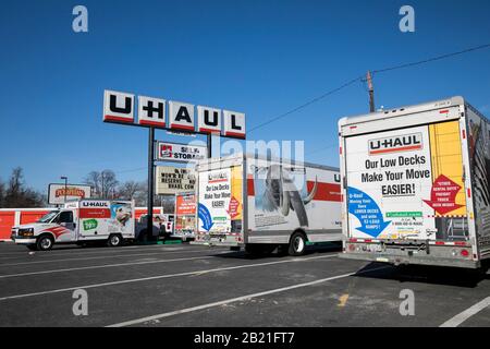 Ein Logo-Schild und bewegliche LKWs außerhalb eines U-Haus-Standorts in Baltimore, Maryland am 22. Februar 2020. Stockfoto