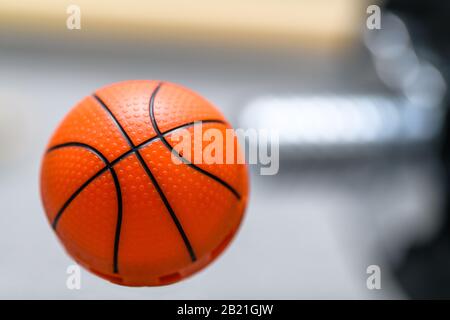 Orangefarbenes Basketball wie ein frischerer Schuhball mit verschwommener Hanteln im Hintergrund.Konzept zur Vermeidung unangenehmen Geruchs oder Geruchs durch Trainingsschuhe. Stockfoto