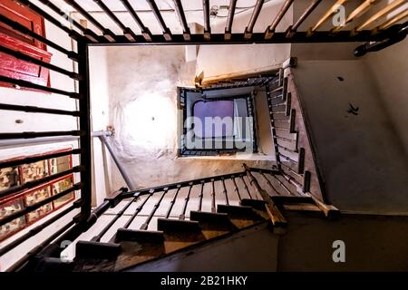 Blick in den niedrigen Winkel abstrakter Blick auf die alte dunkle Treppentreppe im heruntergekommenen Apartmentgebäude in Lemberg, Ukraine Stockfoto