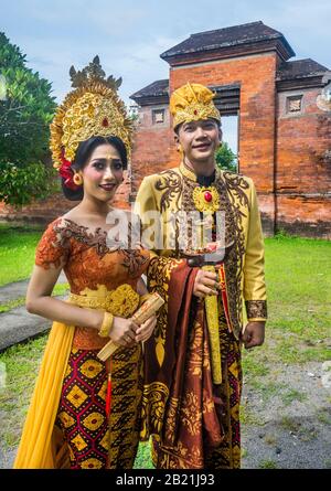 Junges Paar in traditioneller Tracht in Pura Meru, einem großen Hindu-Tempelkomplex in Mataram, Lombok, West Nusa Tenggara Provinz, Indonesien Stockfoto