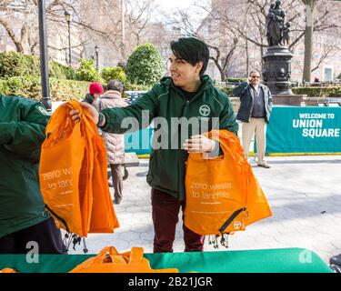 New York, USA. Februar 2020. Mitarbeiter des New York City Department of Sanitation verteilen kostenlose wiederverwendbare Beutel an New Yorker auf dem Union Square Farmers Market am Vorabend des Plastiksackverbots, das am 1. März in Kraft tritt. Kredit: Enrique Shore/Alamy Live News Stockfoto