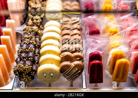 Viele rote gelbe Päpste in Eisdielen im berühmten Florence Italy Firenze Centrale Mercato und Kuchen mit Schokolade Stockfoto