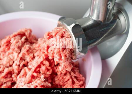 Der vordere Teil der Fleischwolf oder Hacken - Maschine mit Hackfleisch in. Zeigt die forcemeat Prozess. Stockfoto