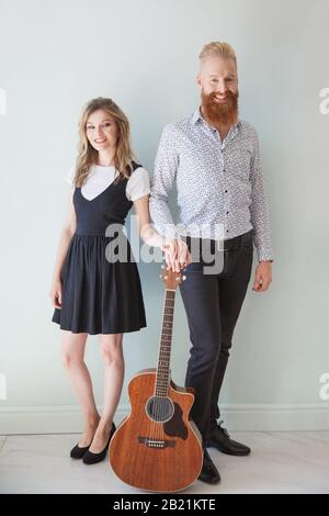 Musikalische Künstler mit Gitarre im Innenbereich Stockfoto