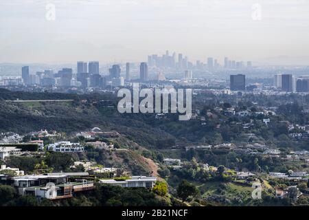 Schlucht-Häuser mit duftiger, rauchiger Stadtansicht von Century City und Downtown Los Angeles Skylines. Stockfoto