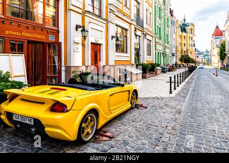 Kiew, Ukraine - 13. August 2018: Alte historische, bunte Straßenbauten der Kiewer Stadt in Podil vozdvizhenka-Viertel mit bunten und gelben Autos Stockfoto