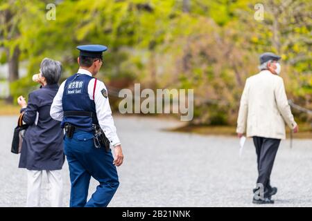 Kyoto, Japan - 17. April 2019: Außenansicht des Innenhofs im Kaiserpalast mit Wachpolizisten Sicherheit, die von Touristen auf der Gartenstraße zu Fuß unterwegs sind Stockfoto