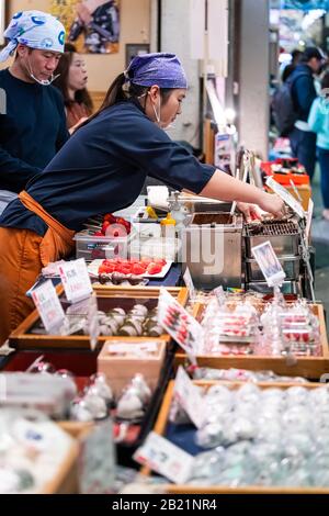 Kyoto, Japan - 17. April 2019: Menschen, die in den Nishiki Market Shops Lebensmittel verkaufen, verkaufen Reiskuchen-Mochi-Bonbons Stockfoto