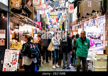 Kyoto, Japan - 17. April 2019: Die enge Straße der Stadt mit den Menschen, die in der Markthalle von Nishiki einkaufen, umhüllte Restaurants und Lebensmittelhändler Stockfoto