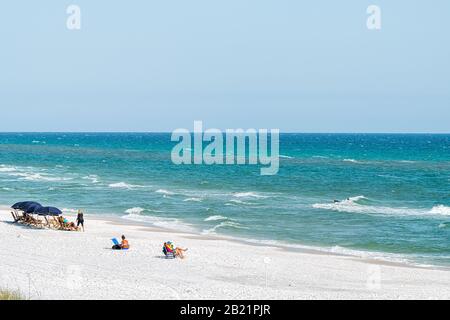 Seaside, USA - 25. April 2018: Strand am sonnigen Tag im Dorf der Stadt Florida mit Blick auf die Menschen am Ufer und den Horizont der Wellen Stockfoto