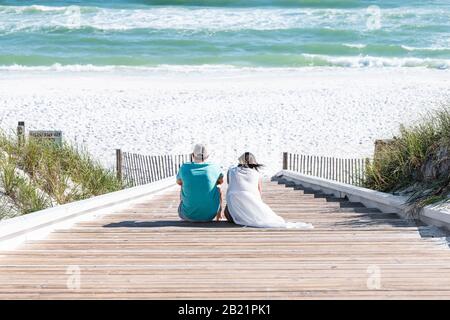 Seaside, USA - 25. April 2018: Strand in Florida Panhandle Town Village mit Holzsteg aus Ozeanholz, hoher Winkel, der auf Stufen hinunterblickt Stockfoto