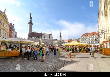 Touristen genießen einen Sommernachmittag in Cafés und Geschäften auf dem Alten Rathausplatz im touristischen Zentrum des mittelalterlichen Estlands. Stockfoto