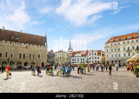 Touristen genießen einen Sommernachmittag in Cafés und Geschäften auf dem Alten Rathausplatz im touristischen Zentrum des mittelalterlichen Estlands. Stockfoto