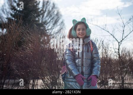 Schöne junge süße Frau in blauem Mantel posiert. Modische modische Kleidung im modischen Stil. Schönes Mädchen im Winter in blauer Jacke im Freien. 9 Jahre alt. Mädchen Stockfoto