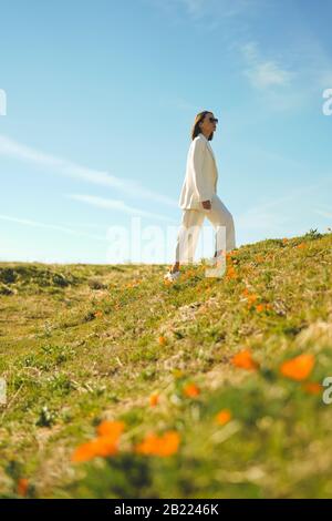 Lifestyle-Foto der schönen jungen Frau in Weiß passt zum Mohnfeld. Freiheit und Unabhängigkeit Stockfoto