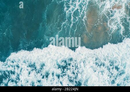 Antenne Blick von oben auf die weißen Schaum auf der Oberfläche des blauen Meer. Stockfoto