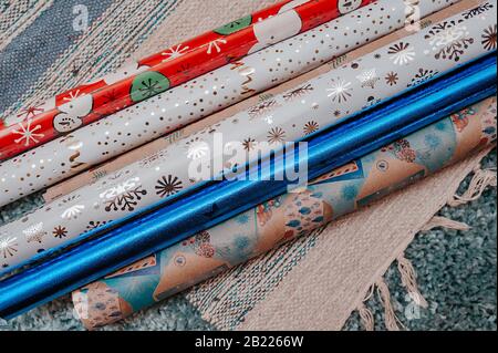 Viele Rollen farbiges Verpackungspapier für weihnachten präsentieren einen hochstapeligen blauen Teppich Stockfoto