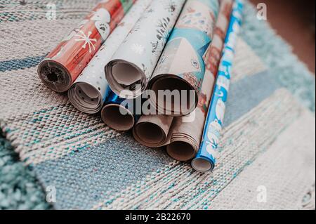 Viele Rollen farbiges Wickelpapier für weihnachten präsentieren eine Serviette aus graublauer Baumwolle Stockfoto