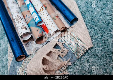 Viele Rollen farbiges Wickelpapier für weihnachten präsentieren eine Serviette aus graublauer Baumwolle Stockfoto