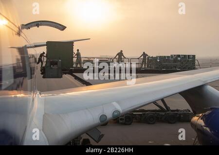 Flugzeuge mit der 38th Expeditionary Logistics Readiness Squadron arbeiten zusammen mit LRS-Mitgliedern der Marine und Marines, um Fracht von einer US-amerikanischen kommerziellen Fluggesellschaft auf die Fluglinie Al Dhafra Air Base, Vereinigte Arabische Emirate, 22. Februar 2020 zur Unterstützung der Native Fury zu entladen. LRS-Mitglieder führten den Empfang, den Download und die Verarbeitung aller Fracht und des Personals und wurden dazu eingesetzt, im Laufe der Übung fast 200 Tonnen Fracht und 3.000 Mitarbeiter zu bewegen. Native Fury ist eine Übung, um die Fähigkeit des Marine Corp zu testen, im Krisenfall schnell Kräfte einzusetzen, und ist auf Trai ausgelegt Stockfoto