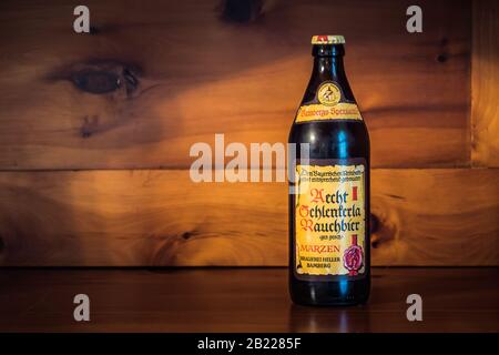 Bamberg - 23. Februar 2020: Eine Flasche Bamberg Rauchtes Bier der berühmten Schlenkerla-Brauerei in Bamberg, Bayern, Deutschland auf einem Holzbackgr Stockfoto