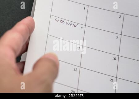 Halten Sie einen Kalender mit Wörtern, Interview geschrieben an einem Datum. Erinnerungskonzept für Bewerbungsgespräche. Stockfoto