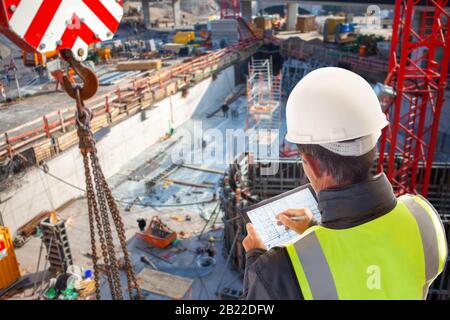 Mitarbeiter des technischen Technikers von ecivil auf der Baustelle, der an einem Tablet-Computer mit Laptop arbeitet Stockfoto