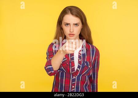 HE, du! Portrait des ernsten unzufriedenen Ingwermädchens in kariertem Hemd, das mit dem Finger auf die Kamera zeigt und mit einem bösen Ausdruck die Schuld beschuldigt, striktes wa Stockfoto