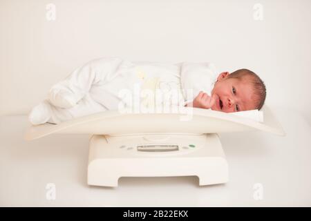 Zehn Tage alt Neugeborenes Kind auf einer Waage, die das Gewicht misst Stockfoto