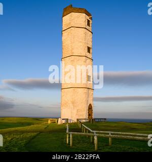 Außenansicht des alten, sonnigen Flamborough Head Lighthouse (historischer weißer Kreide-Achteckturm) und tiefblauer Himmel - in der Nähe von Bridlington, England, Großbritannien. Stockfoto