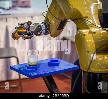 Futuristischer Roboterarm, der Bier in ein Glas gießt Stockfoto