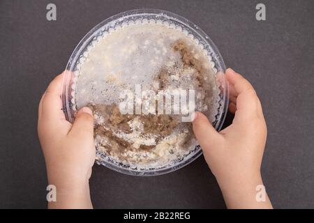 Kinderhände mit Jellied-Fleisch, Knochengelee in Kunststoffbox Stockfoto