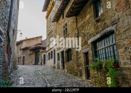 Eine gepflasterte Straße in Pérouges, einer mittelalterlichen ummauerten Stadt 30 km nordöstlich von Lyon, hat den Status eines der schönsten Dörfer Frankreichs verliehen. Stockfoto