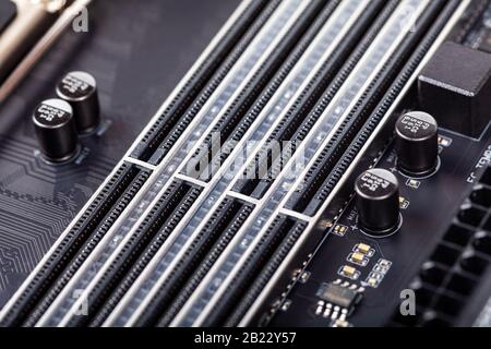 Schließen Sie leere RAM-Steckplätze auf einem modernen schwarzen silberfarbenen Motherboard ab. DDR4-, ddr5-Speichersteckplätze mit wahlfreiem Zugriff, RAM-Platzierung. Makroelektronik Stockfoto