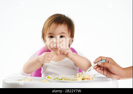 afroamerikanische Fütterung kaukasisches Baby isoliert auf weißem Hintergrund Stockfoto