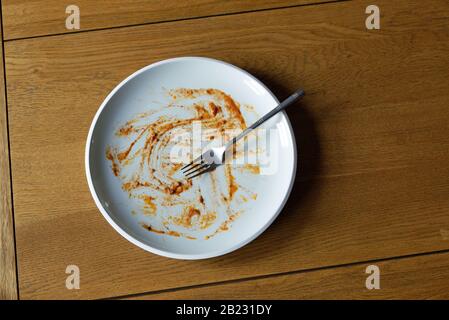 Ungewaschene schmutzige Platte nach einer Mahlzeit auf dem Tisch Stockfoto