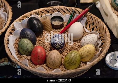 Furstenberg, Deutschland. Februar 2020. Farbenfroh bemalte Ostereier in der Reihenfolge der verschiedenen Malstufen (im Uhrzeigersinn von rechts oben) liegen mit einem Pinsel in einem Korb am Ostereiermarkt im Schloss Fürstenberg. Die Ausstellung läuft bis zum 01.03.2020. Foto: Swen Pförtner / dpa Credit: Dpa Picture Alliance / Alamy Live News Stockfoto