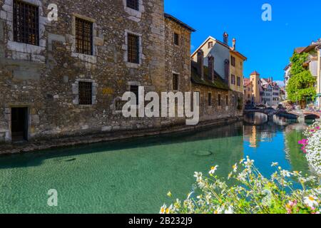 Der Fluss Thiou und die Seite des mittelalterlichen Le Palais de l'Ile von Quai de l'Ile, Annecy, Frankreich, an einem hellen Septembertag aus gesehen Stockfoto