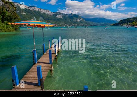 Ein Steg- und Tretboot auf dem See von Annecy, einem der größten Seen in Frankreich, der als der sauberste See Europas bekannt ist, vom Jardins de l'Europe Park aus betrachtet. Stockfoto