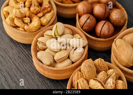 Nussset in einer Schüssel auf schwarzem Holzhintergrund Stockfoto