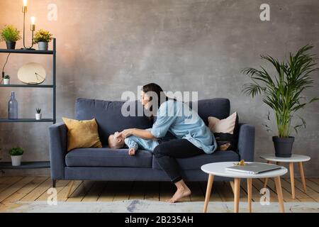 Junge Mutter Spielt mit Kindern auf der Couch. Glückliche Familie. Häuslicher Komfort. Stockfoto