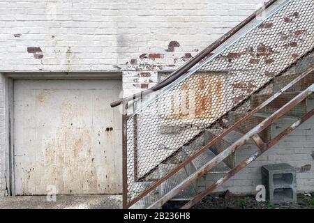 Ein Gasse Lagerhaus, die Tür mit verrosteter Treppe zum Büro lädt und empfängt Stockfoto