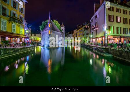 Le Palais de I'lle, ein mittelalterliches Schloss und ein ehemaliges Gefängnis mitten im Fluss Thiou in Annecy, Frankreich, heute ein Kunst- und Geschichtsmuseum, bei Nacht. Stockfoto