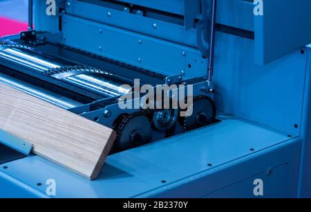 Nahaufnahme eines Tischlers mit einer Kreissäge, um eine große Holzplatte zu schneiden. Stockfoto