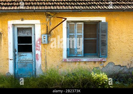 Verlassenes, altes Haus mit gelben Wandfliesen und Glasbruch Stockfoto