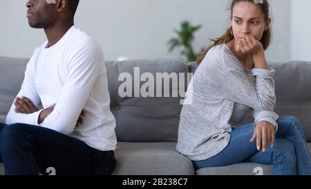 Verärgerte Frau, die sich schuldig fühlt, nachdem sie sich mit dem afroamerikanischen Mann gestritten hat Stockfoto
