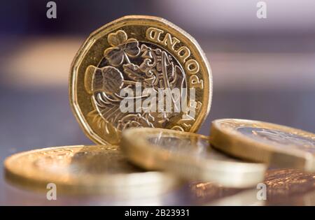 Britische Pfund und ein £2-Münzschuss-Makro auf einer reflektierenden Oberfläche Stockfoto