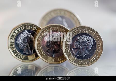 Britische Pfund und ein £2-Münzschuss-Makro auf einer reflektierenden Oberfläche Stockfoto