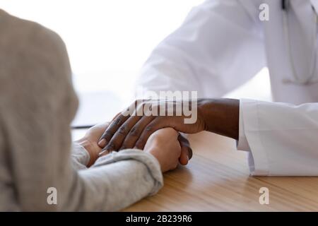 Schließen Sie den afroamerikanischen Arzt, der die weibliche Patientin unterstützt Stockfoto