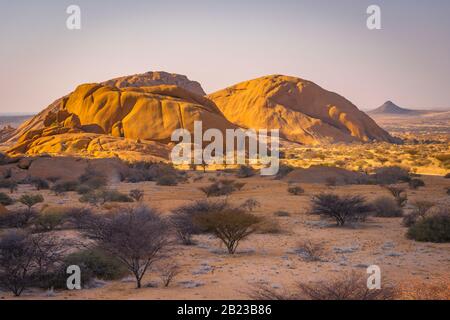 Die Pondoks nahe dem Spitzkoppe-Berg bei Sonnenuntergang in Namibia. Stockfoto